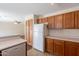 Kitchen with oak cabinets, white refrigerator, and ample storage space, adjacent to the dining area, and plenty of countertop at 22320 W Morning Glory St, Buckeye, AZ 85326