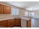 Well-organized kitchen with oak cabinets, countertops with view of the dining area, and a dishwasher at 22320 W Morning Glory St, Buckeye, AZ 85326