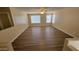 Upstairs living room featuring wood-look floors, neutral paint, and natural light from two windows at 22320 W Morning Glory St, Buckeye, AZ 85326