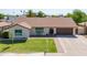 Inviting single-story home with lush green lawn and brick-lined driveway, and a two-car garage at 2329 S Elm --, Mesa, AZ 85202