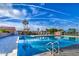Beautiful community pool featuring clear blue water, poolside seating, and palm trees in a serene setting at 2329 S Elm --, Mesa, AZ 85202