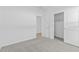 A minimalist bedroom with gray carpet, white walls, and a closet with sliding doors at 23385 W Burton Ave, Buckeye, AZ 85326