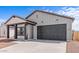 Attractive home with a two-car garage, covered porch, tidy landscaping, and a modern design at 23385 W Burton Ave, Buckeye, AZ 85326
