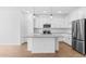 Well-lit kitchen featuring white cabinets, stainless steel appliances, and an island with pendant lighting at 23385 W Burton Ave, Buckeye, AZ 85326
