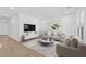 Bright living room featuring wood floors, neutral-toned furniture, and a modern media center at 23385 W Burton Ave, Buckeye, AZ 85326