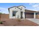 Attractive, one-story home with brown gravel landscaping and a dark brown garage door at 23456 W Fulton St, Buckeye, AZ 85326