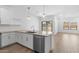 Well-appointed kitchen featuring white cabinets, stainless appliances, and a breakfast bar overlooking the living area at 23456 W Fulton St, Buckeye, AZ 85326