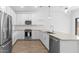 Bright, open kitchen features white cabinets, stainless steel appliances, and wood-look flooring at 23456 W Fulton St, Buckeye, AZ 85326