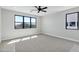 Bright bedroom featuring a ceiling fan, carpet flooring, and large black-framed windows at 26619 S 169Th Pl, Queen Creek, AZ 85142