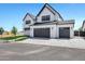 Modern two-story home featuring white brick, dark accents, and a spacious driveway leading to attached garages at 26619 S 169Th Pl, Queen Creek, AZ 85142