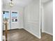 Bright foyer with hardwood floors, decorative wall paneling, and an elegant light fixture highlighting the entrance at 26619 S 169Th Pl, Queen Creek, AZ 85142