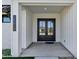 Close-up view of the double front doors, showing modern design with a covered porch and clean, white accents at 26619 S 169Th Pl, Queen Creek, AZ 85142
