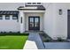 Elegant front entry featuring double doors, modern lighting, and meticulous landscaping enhancing curb appeal at 26619 S 169Th Pl, Queen Creek, AZ 85142