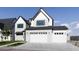 Spacious three-car garage featuring white doors complementing the house's white brick exterior and black roof at 26619 S 169Th Pl, Queen Creek, AZ 85142