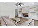 Living room featuring a modern brick fireplace, a gray sofa, and open floorplan at 26619 S 169Th Pl, Queen Creek, AZ 85142