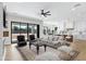 Bright, open-concept living room with large windows, fireplace and modern furniture at 26619 S 169Th Pl, Queen Creek, AZ 85142