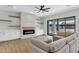 Bright living room features a modern fireplace, wood floors, and sliding glass doors at 26619 S 169Th Pl, Queen Creek, AZ 85142