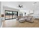 Open living room featuring modern furnishings, expansive sliding glass doors and a glimpse of the kitchen at 26619 S 169Th Pl, Queen Creek, AZ 85142