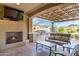 Inviting covered patio with fireplace, outdoor kitchen, grill, and lounge area at 27021 W Kerry Ln, Buckeye, AZ 85396
