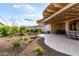 Extended covered patio with outdoor kitchen, dining, and lounge area surrounded by mature landscaping at 27021 W Kerry Ln, Buckeye, AZ 85396