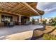 Extended covered patio with outdoor kitchen, dining, lounge area, and fireplace at 27021 W Kerry Ln, Buckeye, AZ 85396