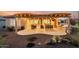 Relaxing covered patio with outdoor kitchen, dining and lounge area overlooking the landscaped backyard at 27021 W Kerry Ln, Buckeye, AZ 85396