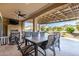 Covered patio with ceiling fan overlooks grill, seating area, and manicured desert landscaping at 27021 W Kerry Ln, Buckeye, AZ 85396