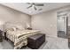 Comfortable bedroom featuring carpet, ceiling fan, side tables and a tufted storage bench at 27021 W Kerry Ln, Buckeye, AZ 85396