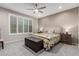 Comfortable bedroom with a ceiling fan, plantation shutters and an upholstered storage bench at 27021 W Kerry Ln, Buckeye, AZ 85396