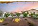 Charming landscape in the front yard with desert plants, rocks, and accent lighting at dusk at 27021 W Kerry Ln, Buckeye, AZ 85396