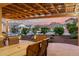Relaxing outdoor dining area under a covered patio with view of professionally landscaped front yard at 27021 W Kerry Ln, Buckeye, AZ 85396