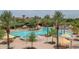 A large community pool with lounge chairs, umbrellas, and palm trees at 27021 W Kerry Ln, Buckeye, AZ 85396