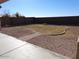 A simple backyard with gravel and a small patch of grass surrounded by a concrete border at 29797 W Mitchell Ave, Buckeye, AZ 85396