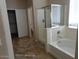 Bright bathroom featuring a glass-enclosed shower and a soaking tub beneath a window at 29797 W Mitchell Ave, Buckeye, AZ 85396