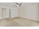 Bedroom featuring carpet floors, a ceiling fan, and a closet with sliding doors at 300 W Windsor Dr, Gilbert, AZ 85233