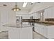 Well-lit kitchen featuring white cabinets, granite countertops, and stainless steel appliances at 300 W Windsor Dr, Gilbert, AZ 85233