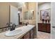 Bathroom featuring double sinks, framed mirror, granite counters, neutral color palette, and tiled floor at 3350 S Holguin Way, Chandler, AZ 85248
