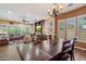 Open-concept dining area featuring stylish chandelier, large wooden table, views into the living room with fireplace at 3350 S Holguin Way, Chandler, AZ 85248