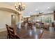 Spacious open concept, showing large wood dining table, chandelier, opening into the living room with lots of natural light at 3350 S Holguin Way, Chandler, AZ 85248