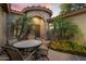 Inviting front courtyard with a stone archway, wrought-iron door, and outdoor dining area at 3350 S Holguin Way, Chandler, AZ 85248
