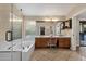 Bright bathroom with double vanity, a soaking tub, and a separate glass enclosed shower at 3842 W Ironwood Dr, Chandler, AZ 85226