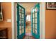 Bedroom view through open French doors, with a bed, carpeted floor, and natural light from the window at 39 E Hoover Ave, Phoenix, AZ 85004