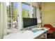 Close-up of a desk with a modern monitor and a view to the lush, green outdoor scenery at 39 E Hoover Ave, Phoenix, AZ 85004