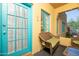 Close up of front porch with turquoise trim and wicker seating creating a cozy, welcoming entrance at 39 E Hoover Ave, Phoenix, AZ 85004
