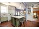 Bright kitchen featuring white cabinets, hardwood floors, an island with seating, and built-in shelving at 39 E Hoover Ave, Phoenix, AZ 85004