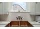Close-up of a farmhouse sink and subway tile backsplash, with a window providing natural light at 39 E Hoover Ave, Phoenix, AZ 85004