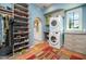 Well-organized laundry area featuring a stacked washer and dryer, ample storage, and a window with natural light at 39 E Hoover Ave, Phoenix, AZ 85004
