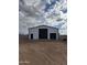 New metal barn construction featuring black trim and roll-up doors with a beautiful sky backdrop at 3989 E Freeman Ln, San Tan Valley, AZ 85140