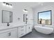 Bright bathroom featuring a soaker tub, dual sinks, white cabinets and quartz countertops at 3989 E Freeman Ln, San Tan Valley, AZ 85140