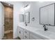 Bathroom with double vanity, white marble counter tops, mirrors, and glass enclosed shower at 3989 E Freeman Ln, San Tan Valley, AZ 85140